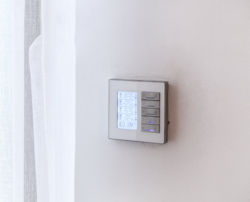 A programmable thermostat on a wall.