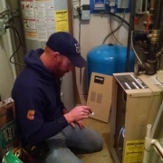H&S Heating and Air Conditioning owner Jeremy Salzbrun troubleshooting an HVAC unit at a home.
