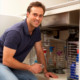 A plumber working under a kitchen sink.