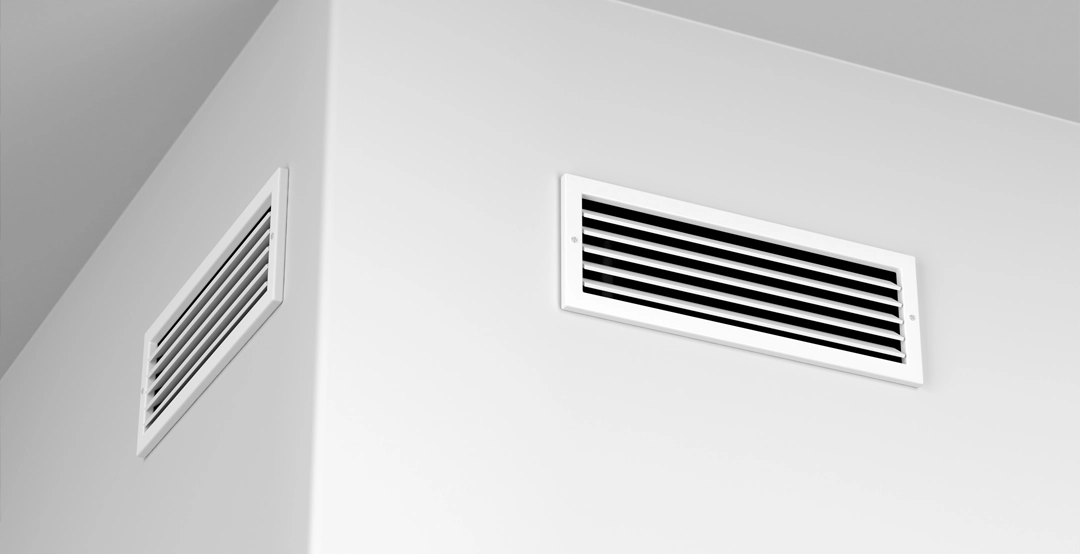 Two air conditioning vents on a wall.