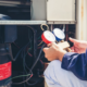 A technician performing an inspection on an air conditioning unit.