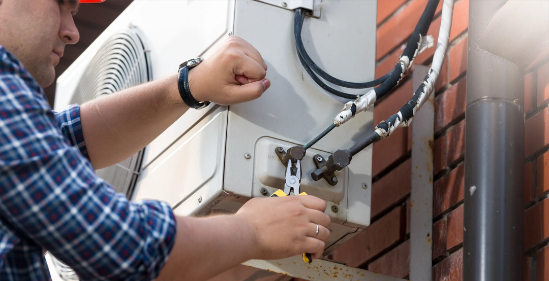 A technician performing maintenance on an air conditioning unit.