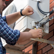 A technician performing maintenance on an air conditioning unit.