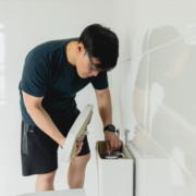 A man inspecting the tank of his toilet for issues.